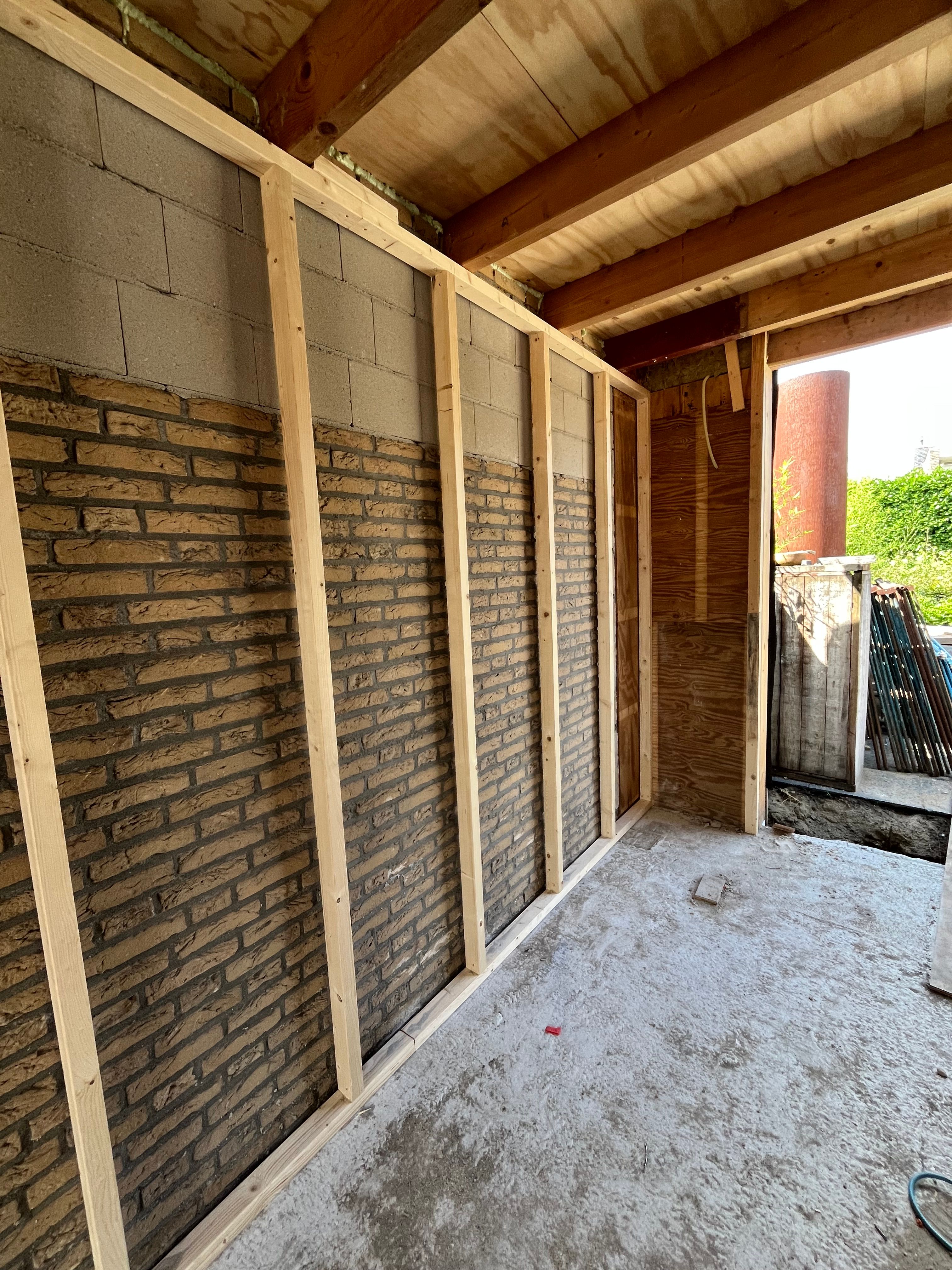 Houten regelwerk langs een bestaande gemetselde wand