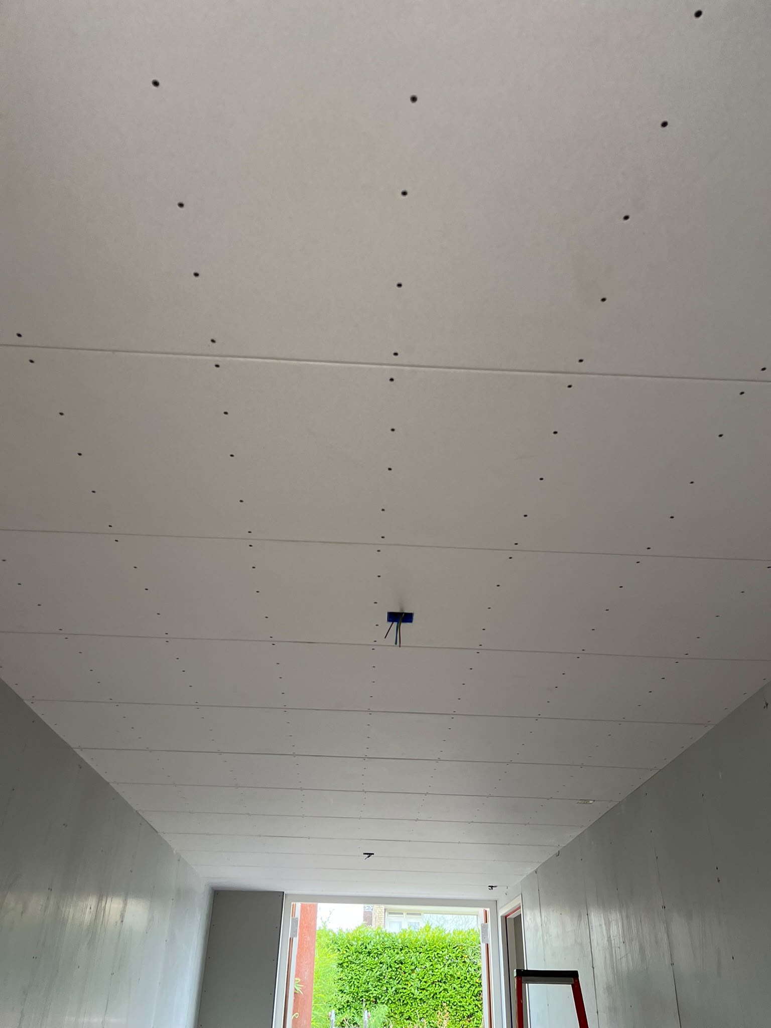 Plafond met nieuwe gipsplaten en aansluitingen voor verlichting