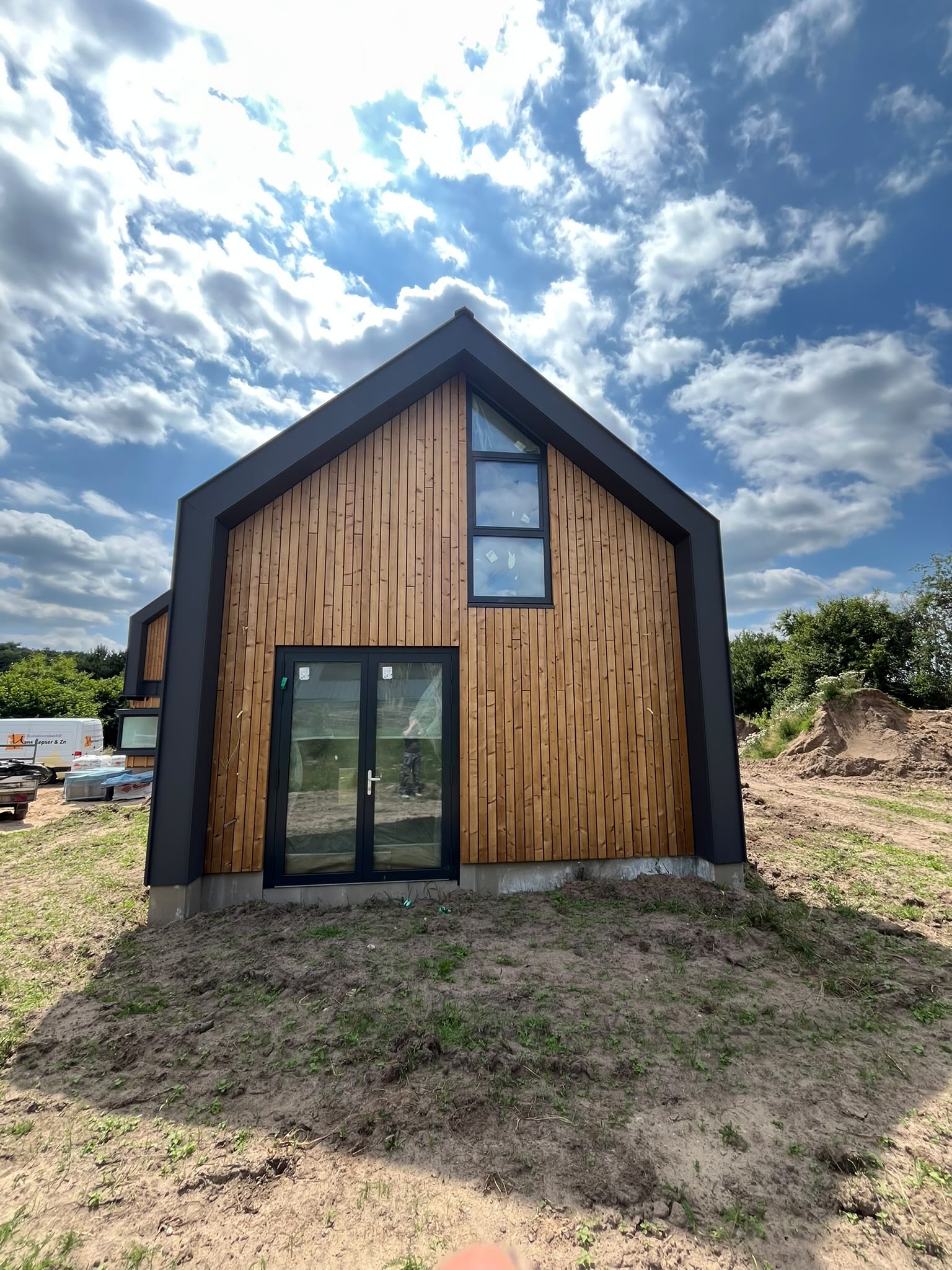 Woning met houten gevelbekleding en donkere kozijnen