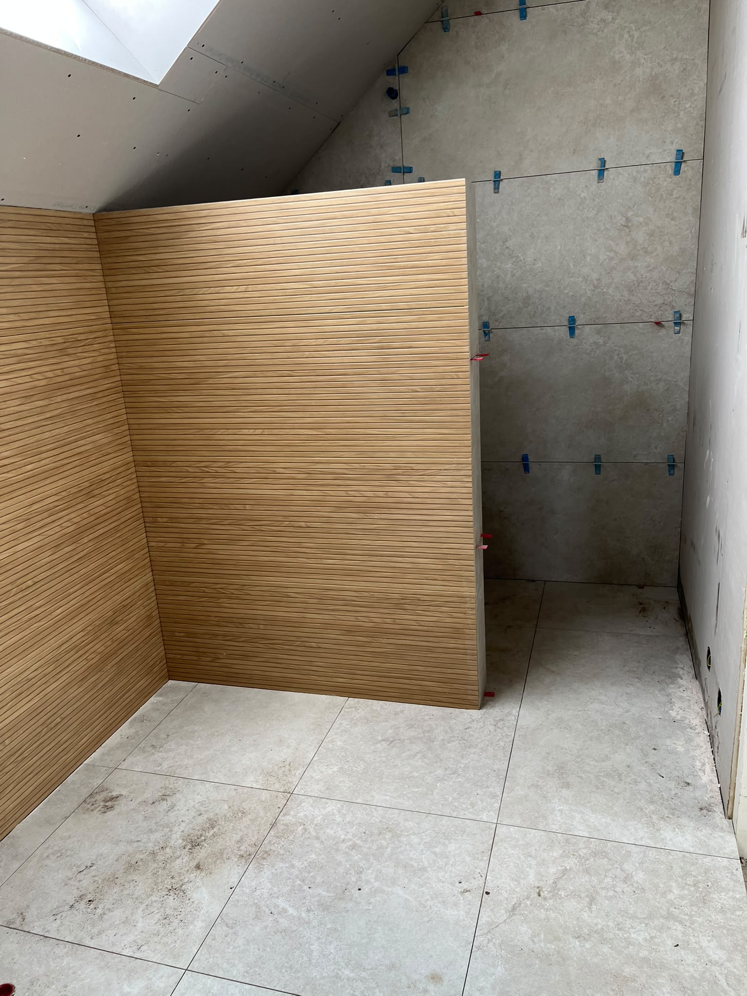 Binnenafbouw van een badkamer met wandbekleding onder een schuin dak